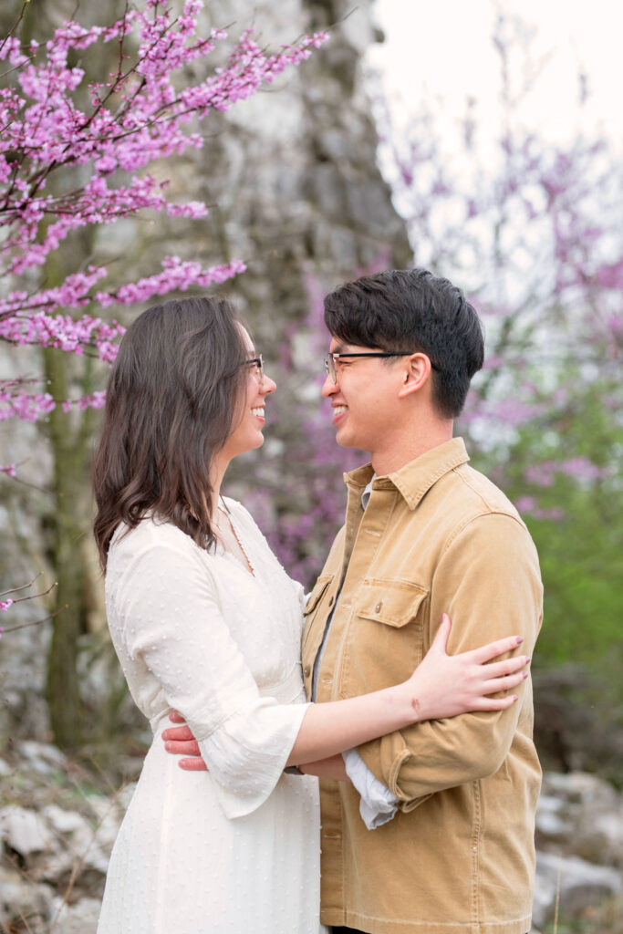 Bride and groom smiling at one another surrounded by purple flowers at their DePauw Nature Park Elopement.