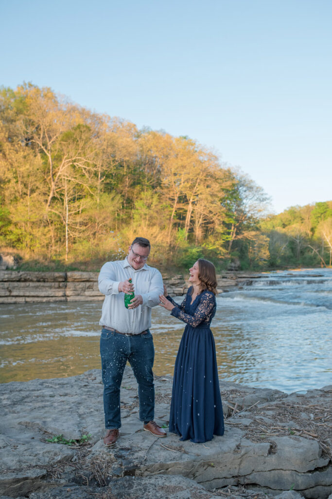 Engaged couple laughs after sparkling water pop.