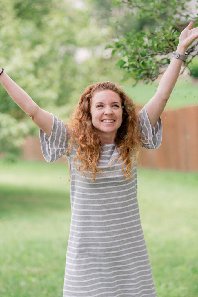 Girl happily tosses leaf confetti into the air as a sustainable photo session alternative to glitter.