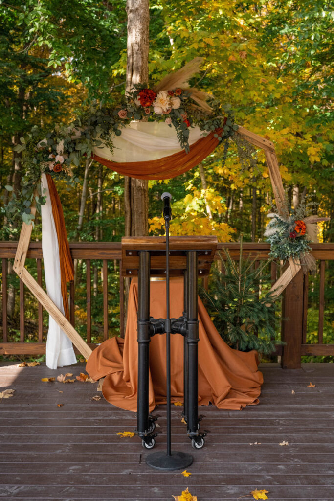 Fall outdoor wedding ceremony arch with tree to plant for unity part of ceremony.