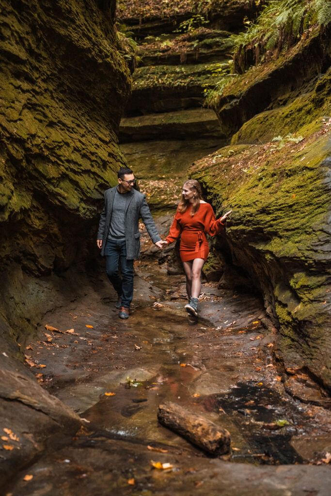 Couple explores a trail with moss-covered rocks at Turkey Run State Park in Indiana.