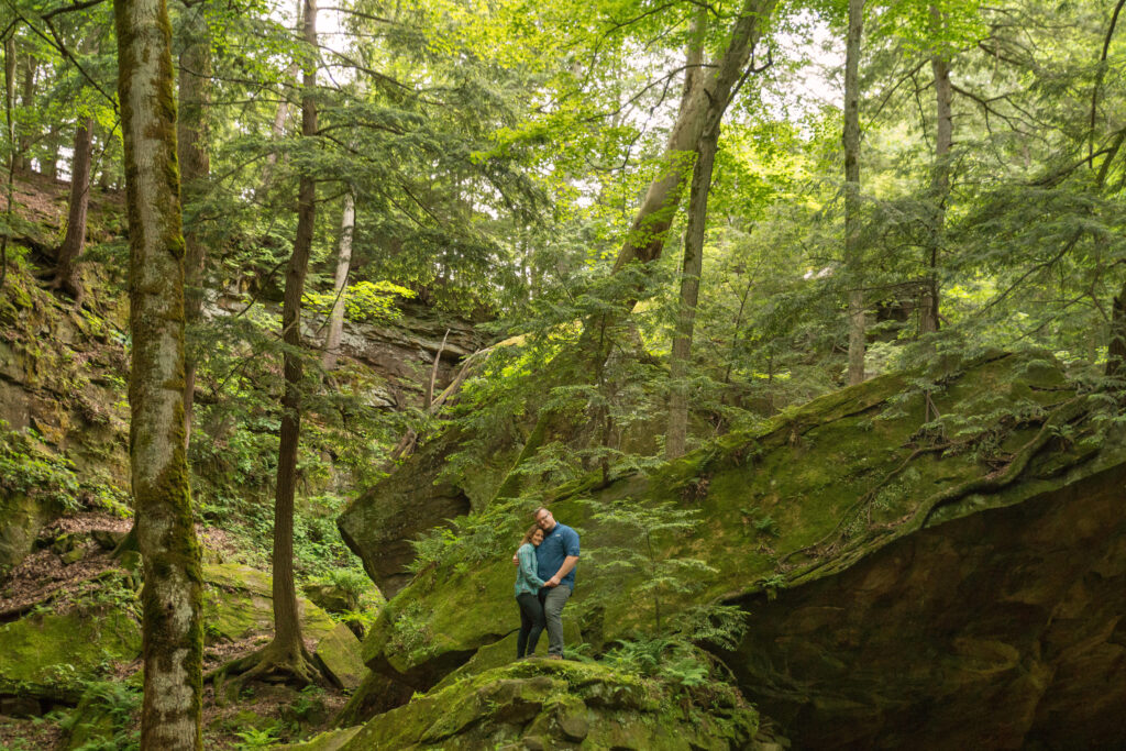 Couple stands on a boulder at Turkey Run State Park in Indiana.
