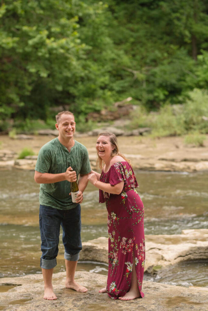 Couple laughs as they pop open sparkling water.