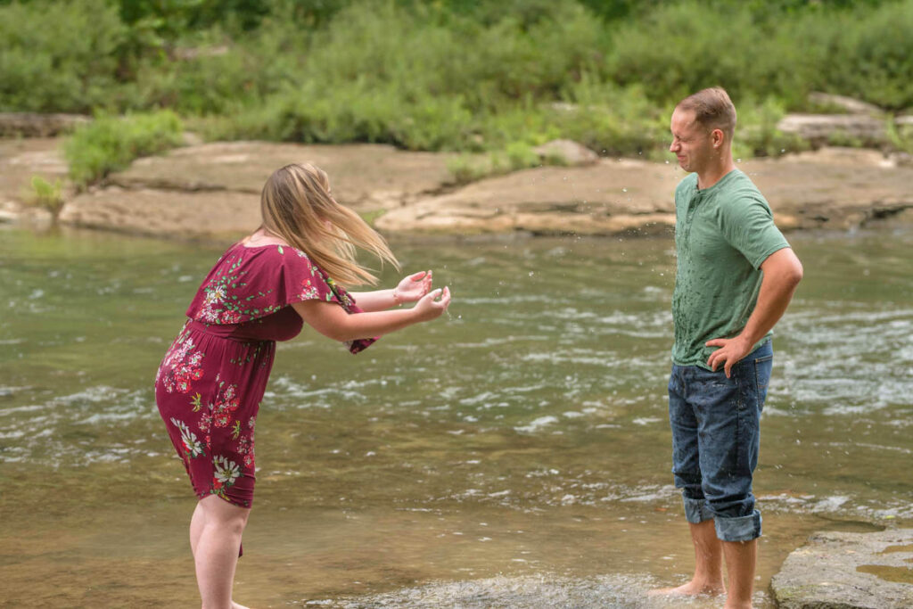 Girl splashes guy with water.