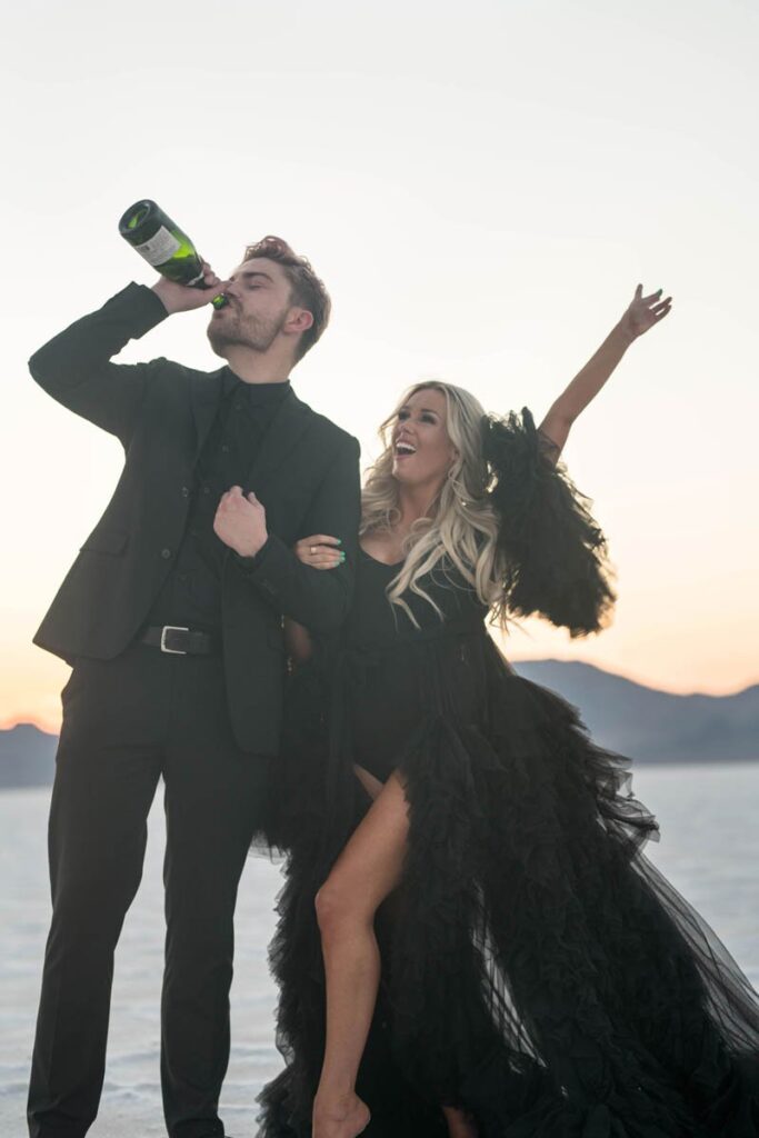 Should I elope like this Bride and groom dressed in black drinking champagne from bottle to celebrate?