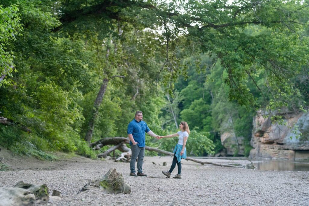 Couple enjoys a dance together on a rock shore next to a creek.