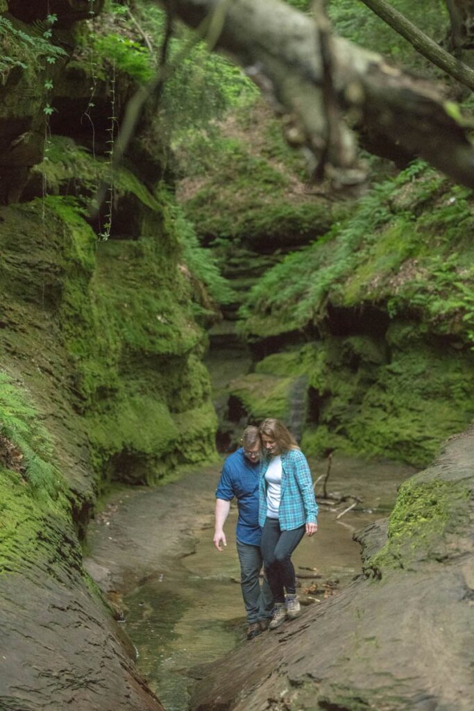 Couple hikes on rocks at Turkey Run State Park in Indiana.