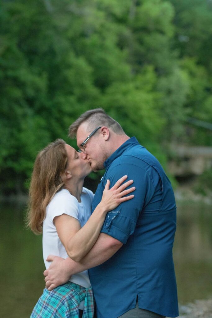 Couple kisses in front of a creek at Turkey Run State Park in Indiana.