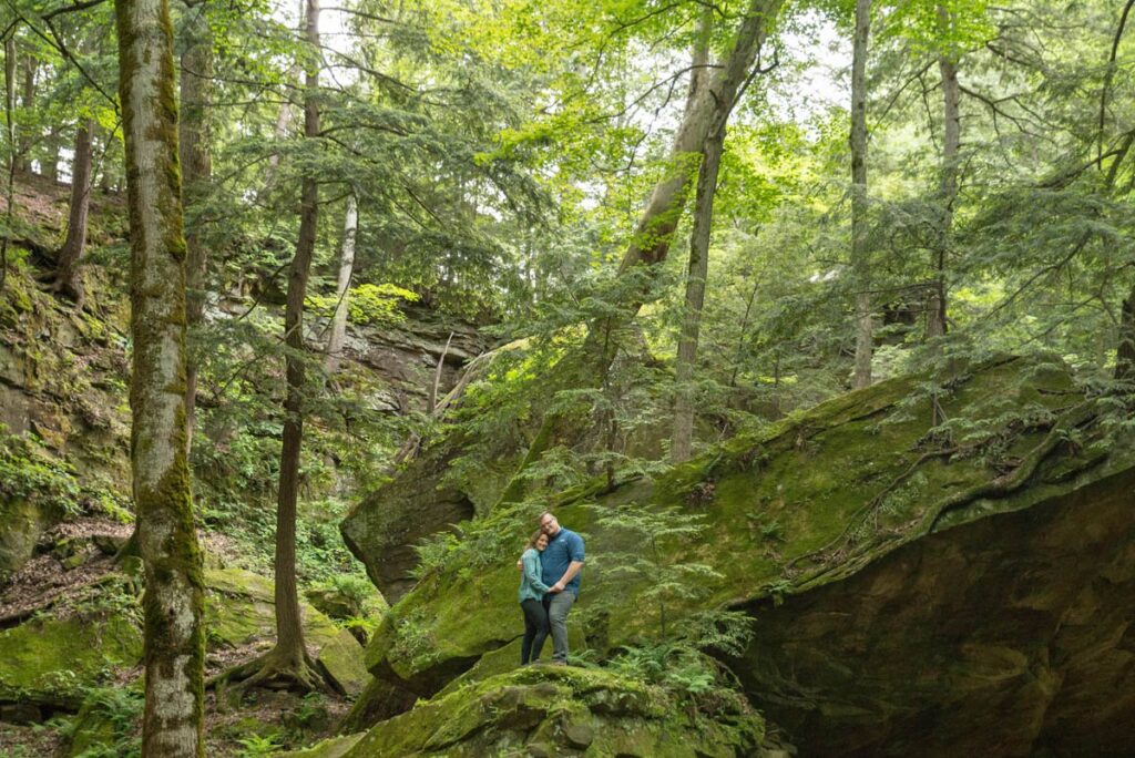 Couple holds one another while standing on a boulder at Turkey Run State Park in Indiana.