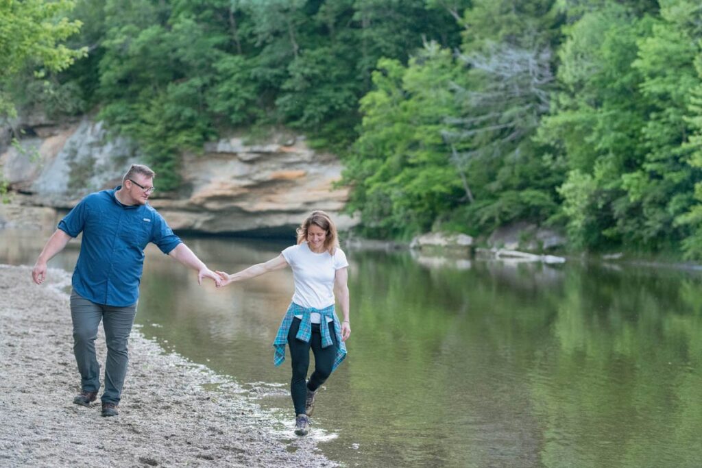 Couple has fun walking through a creek.