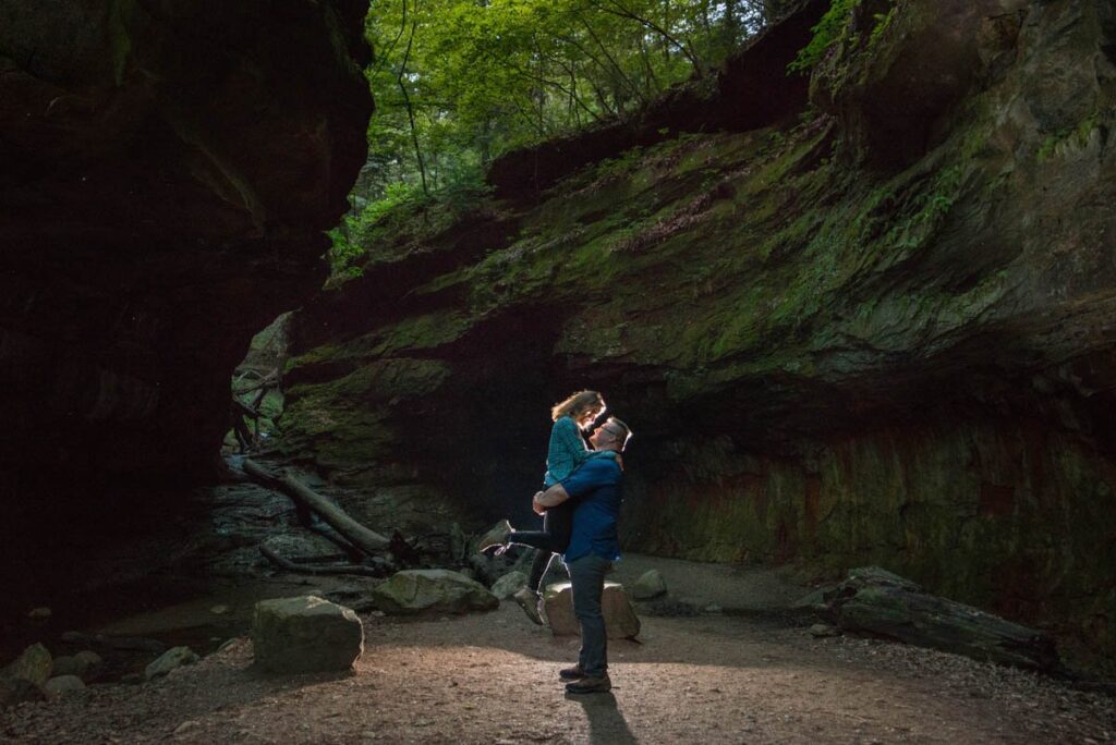 Man lifts up woman in the middle of a rocky gorge at Turkey Run State Park in Indiana.