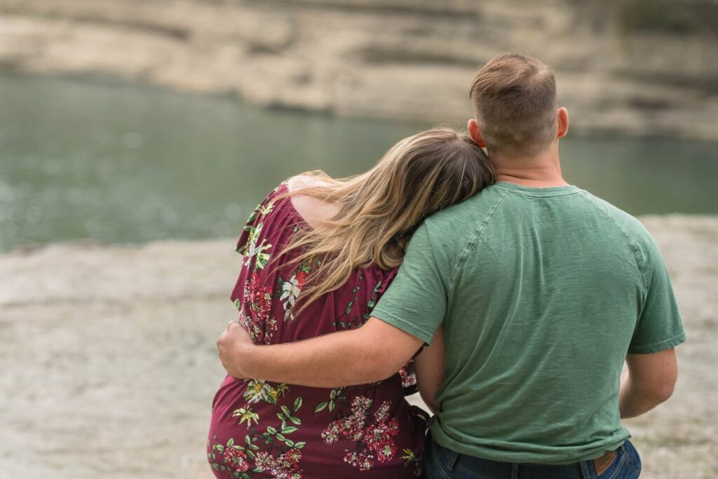 Couple snuggles on a rock near Cataract Falls.