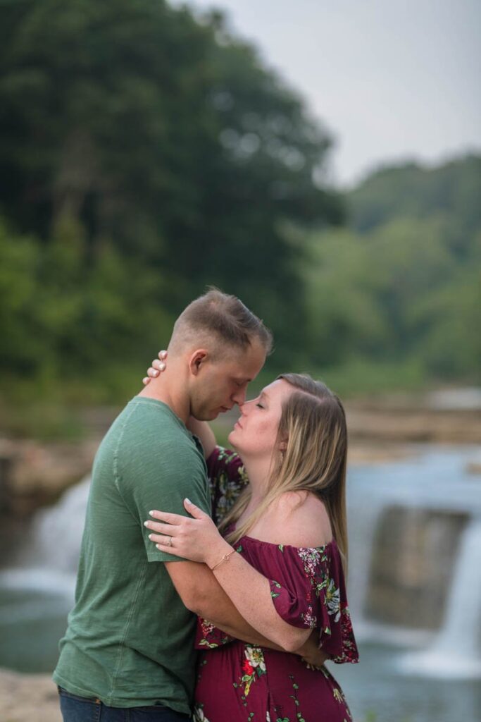 Couple touches noses in front of Cataract Falls.