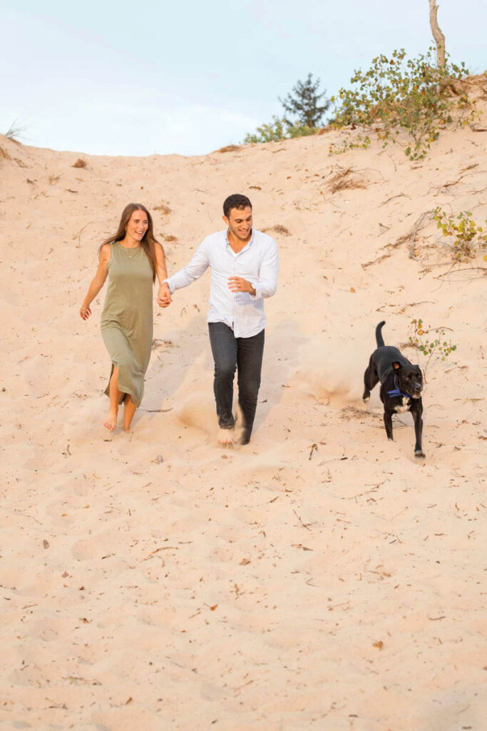 Couple runs with their dog at Indiana Dunes.