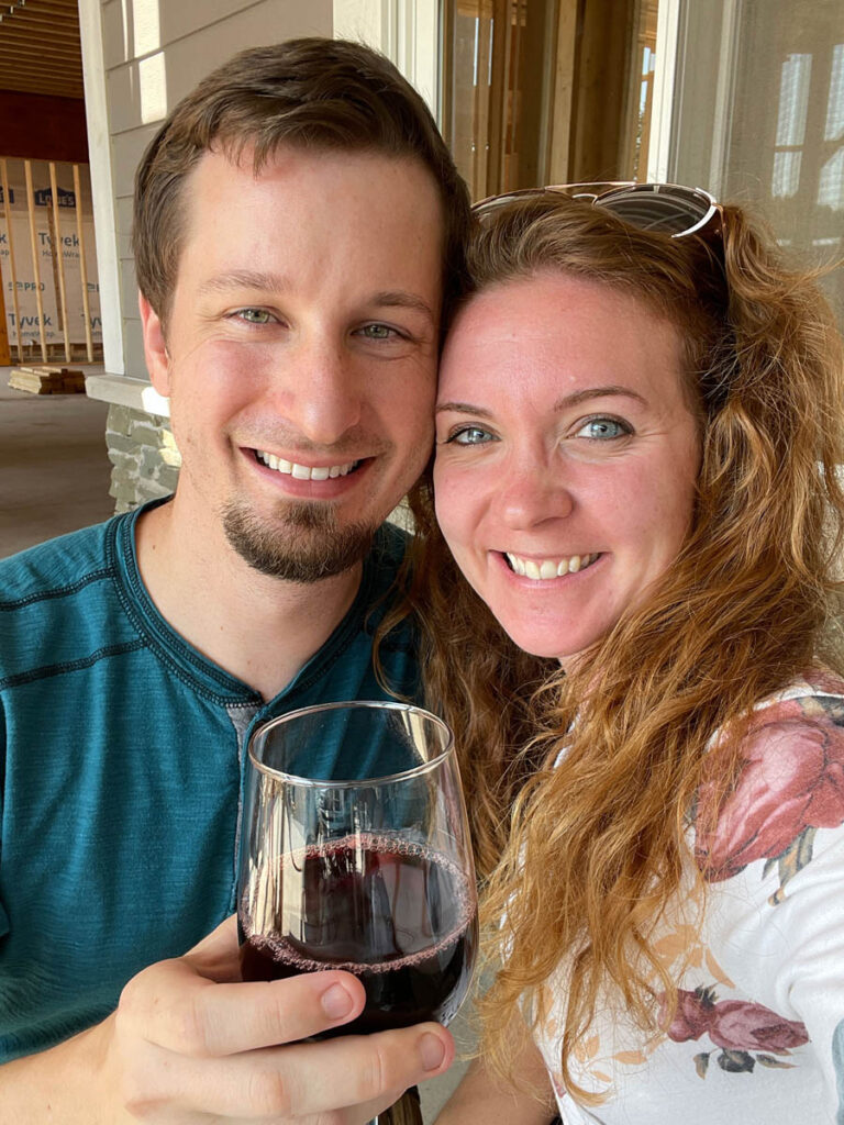 Smiling couple drinking wine at winery near Indiana Dunes State Park.