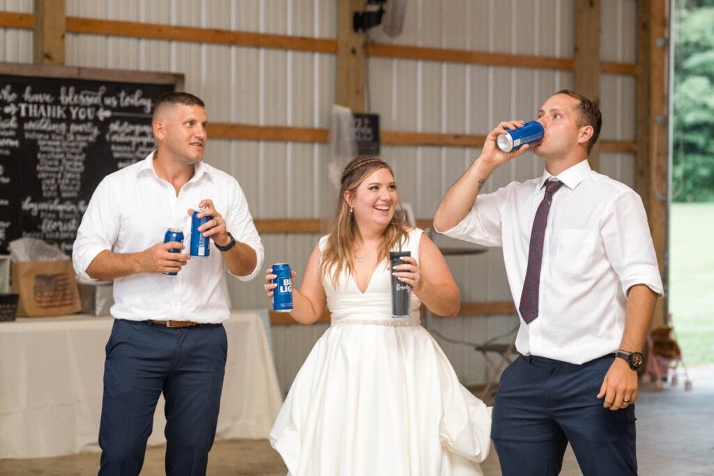 Bride, groom, and groom's brother drink together during wedding reception.