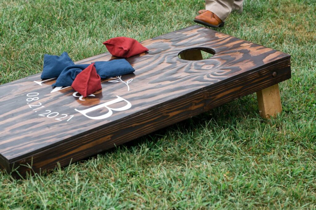 Cornhole game on custom cornhole boards with bride and groom's initials at an Indiana outdoor wedding.