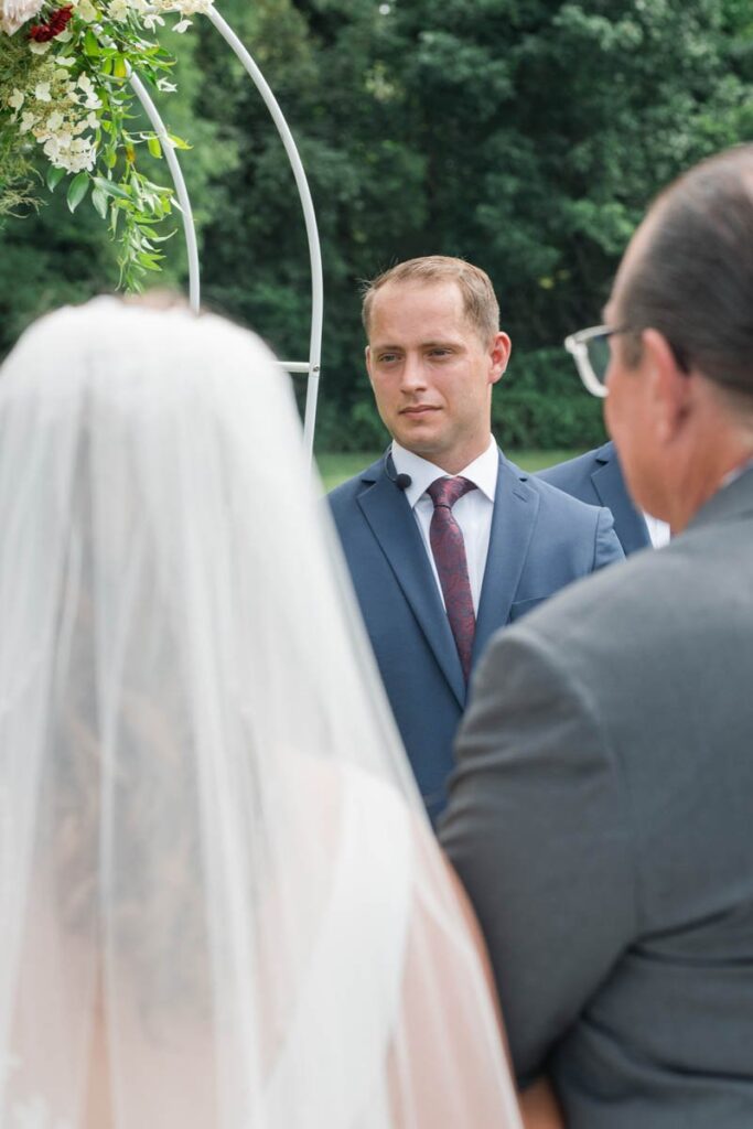 Groom is crying when bride reaches the end of the aisle with her father.