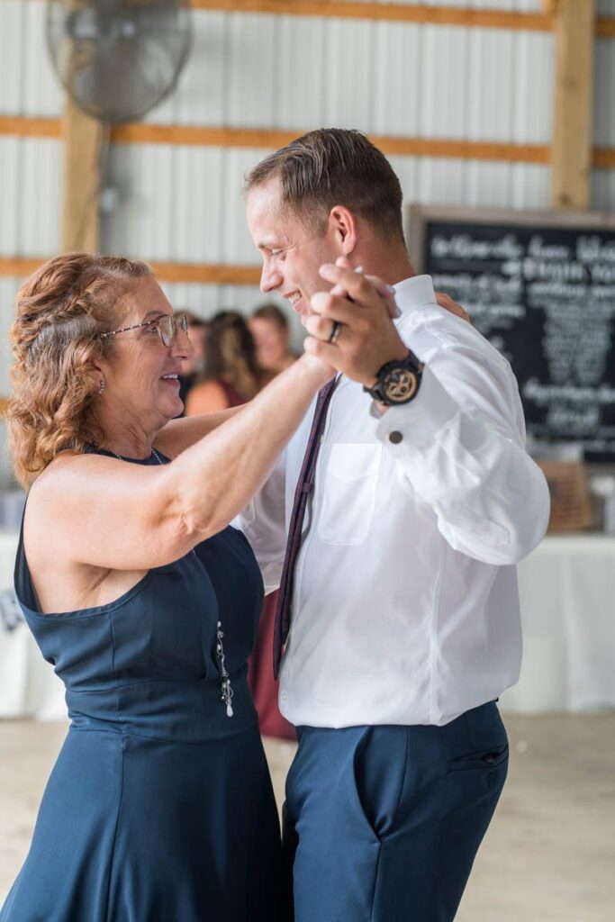 Groom slow dances with his mother at wedding reception.
