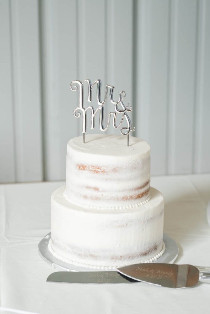 White wedding cake with Mr. & Mrs. cake topper.