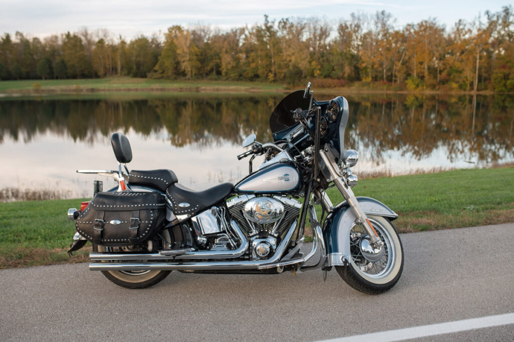 Side view of Harley Davidson bike sitting in front of lake.