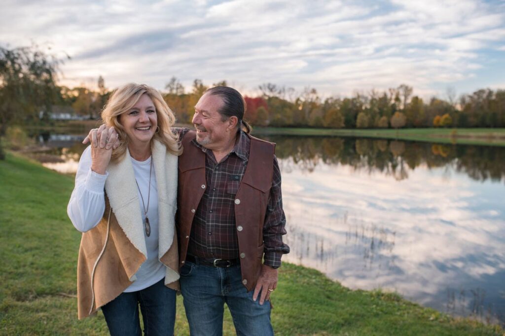 Husband smiling at his wife while she laughs at a couples photography session.