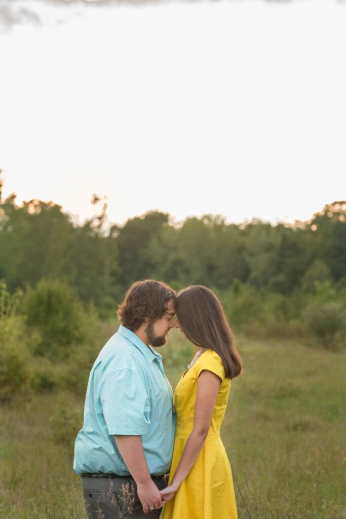 Couple rests forehead to forehead in a quiet moment at sunset.