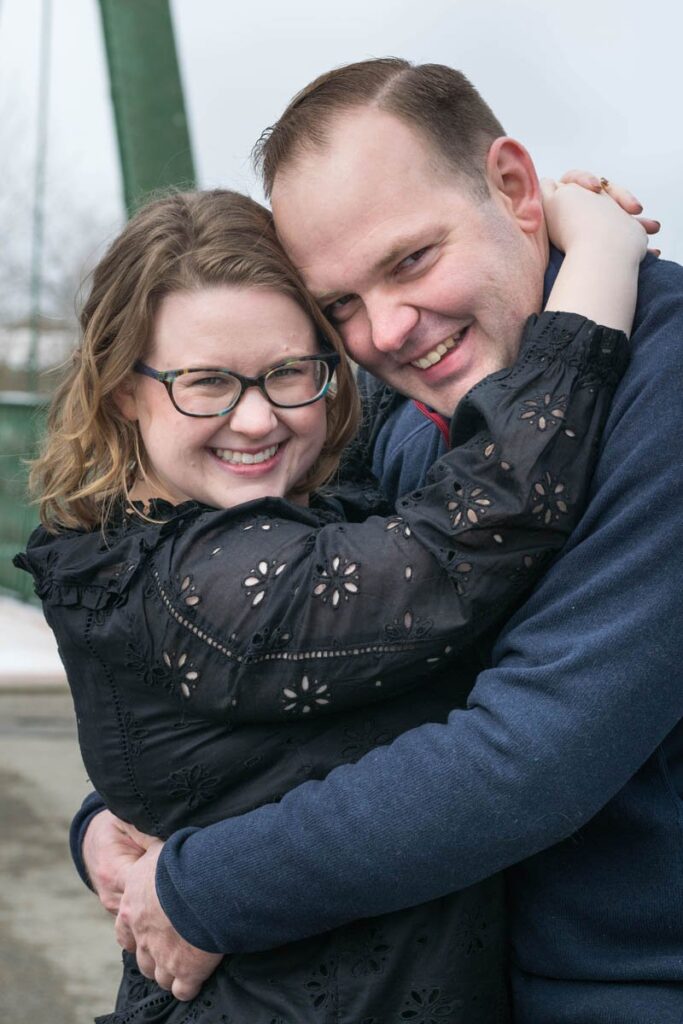 Couple hugs really closely with big smiles.