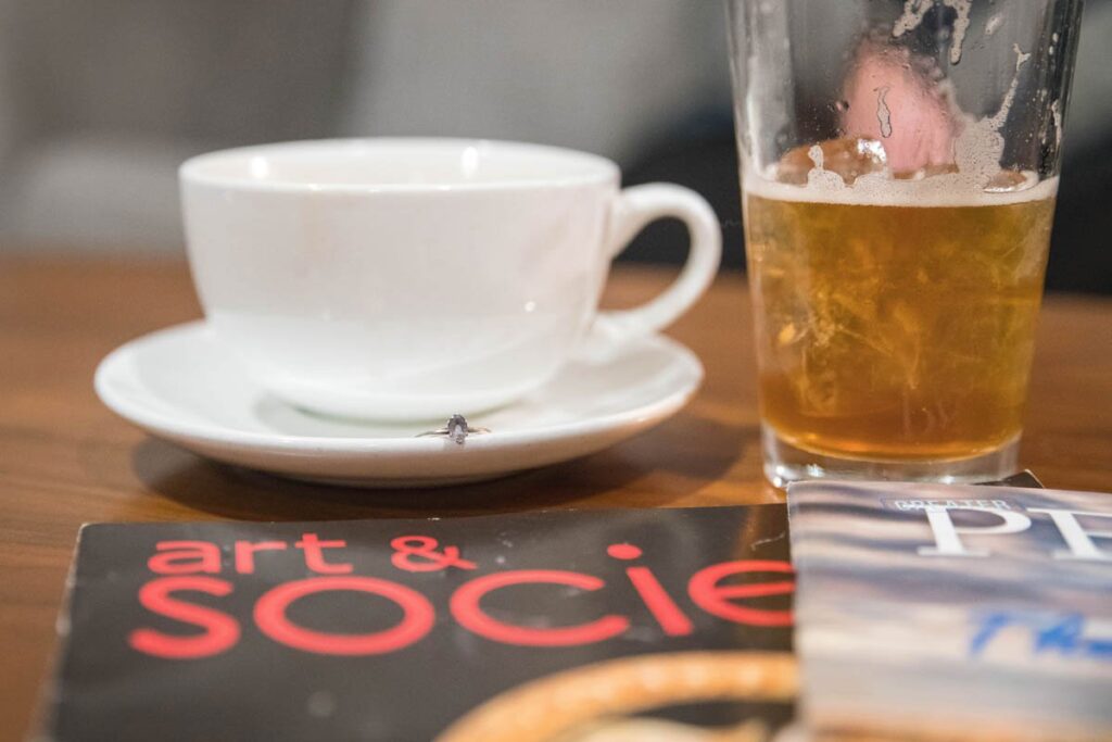 Engagement ring sitting near coffee cup.