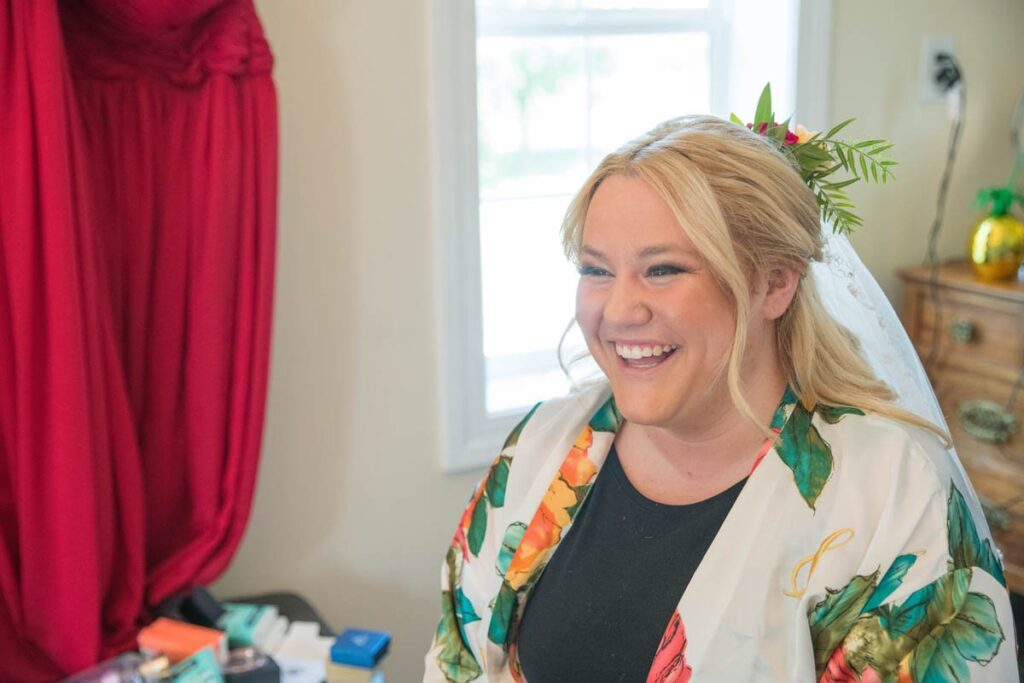 Bride smiling and laughing as she gets ready.