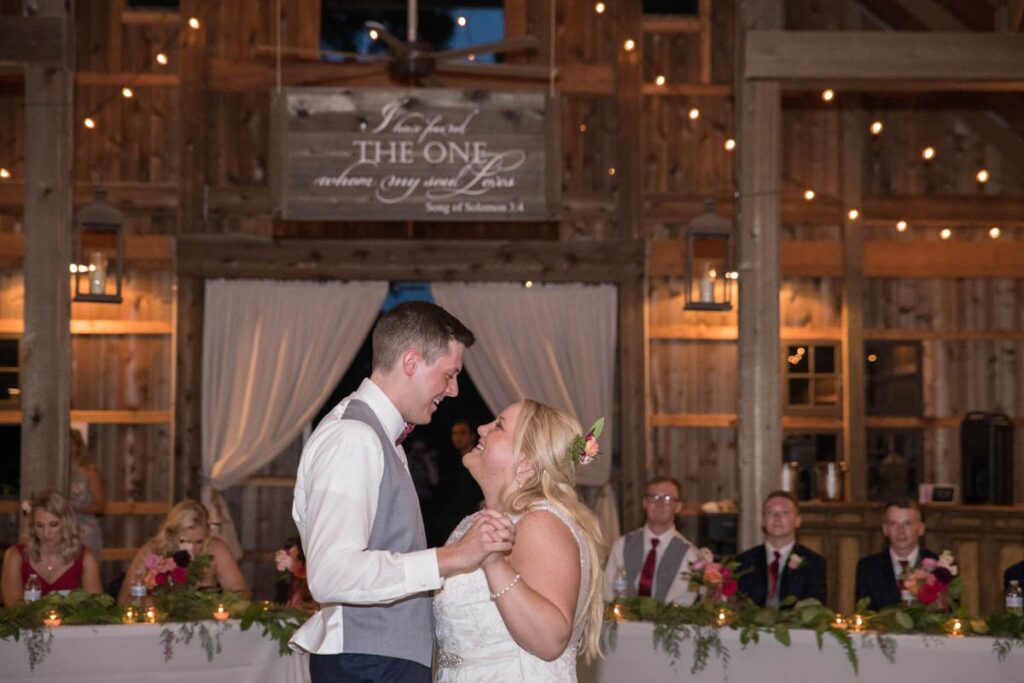 Bride and groom share their first dance at barn wedding reception.