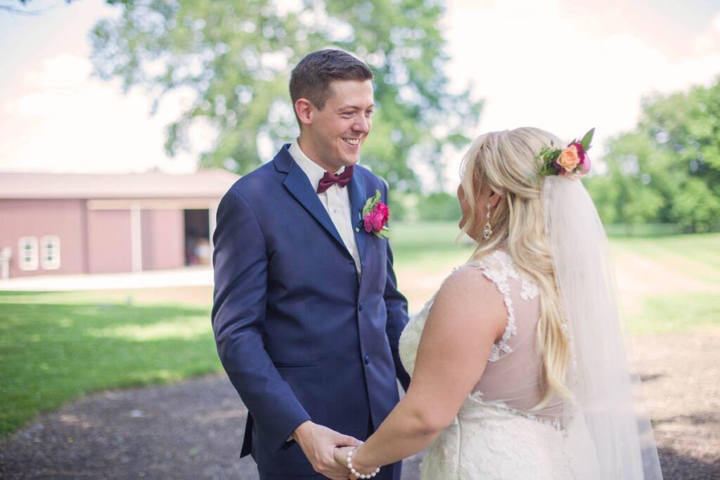 Bride and groom laugh and smile during their first look.