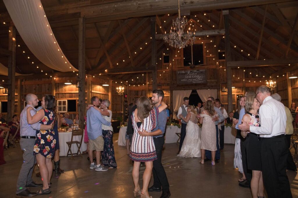 Couples dancing at barn wedding reception.