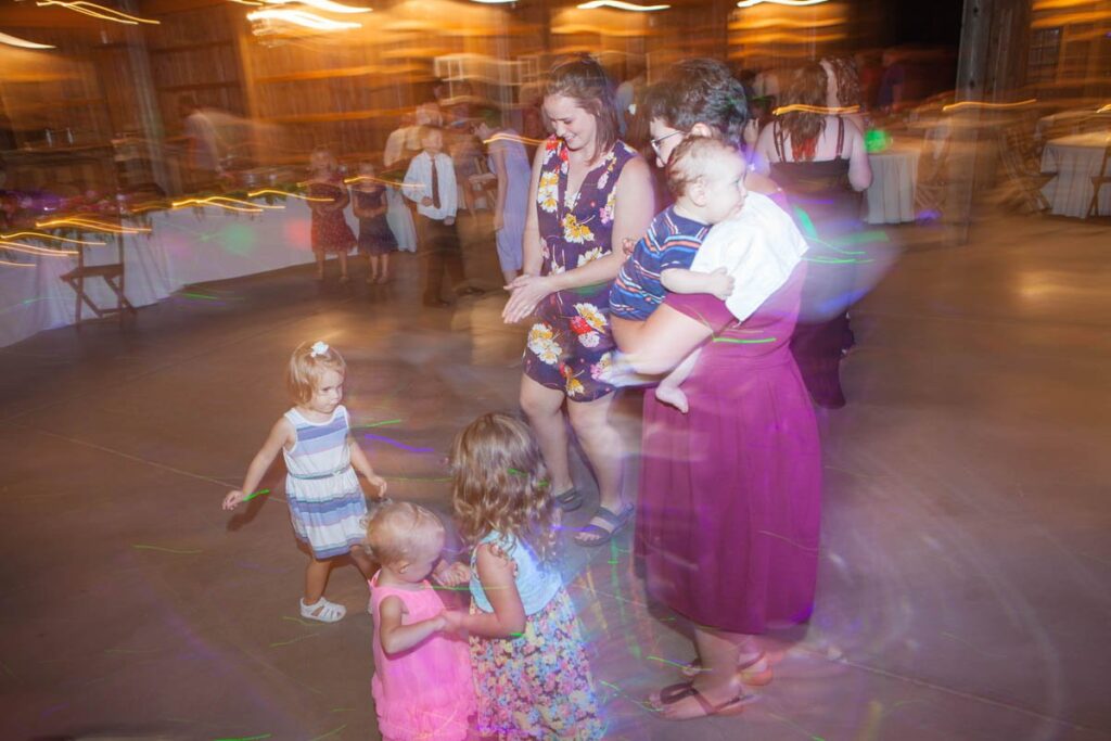 Woman dancing with children at wedding reception.
