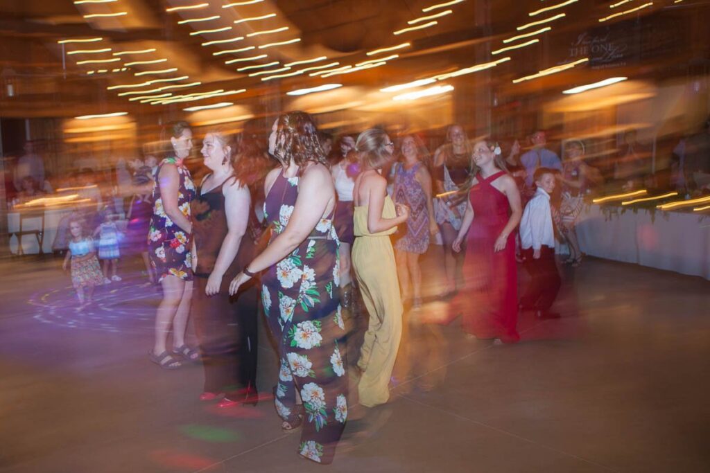 Group of girls dancing together at wedding reception.