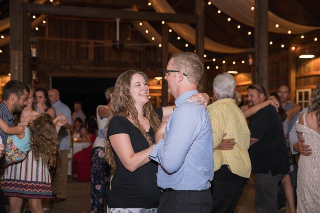 Man and woman dancing at wedding reception and smiling.