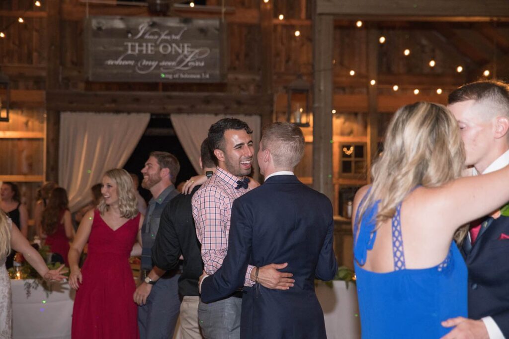 Two men dancing together happily at wedding reception.