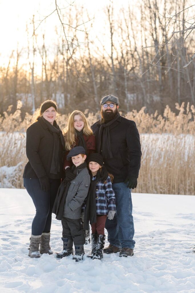 Family smiles during photoshoot in the snow in Indiana.