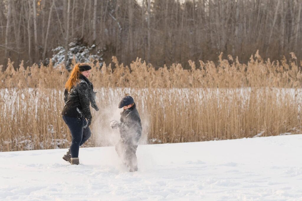 After their photoshoot in the snow, family has a snowball fight.