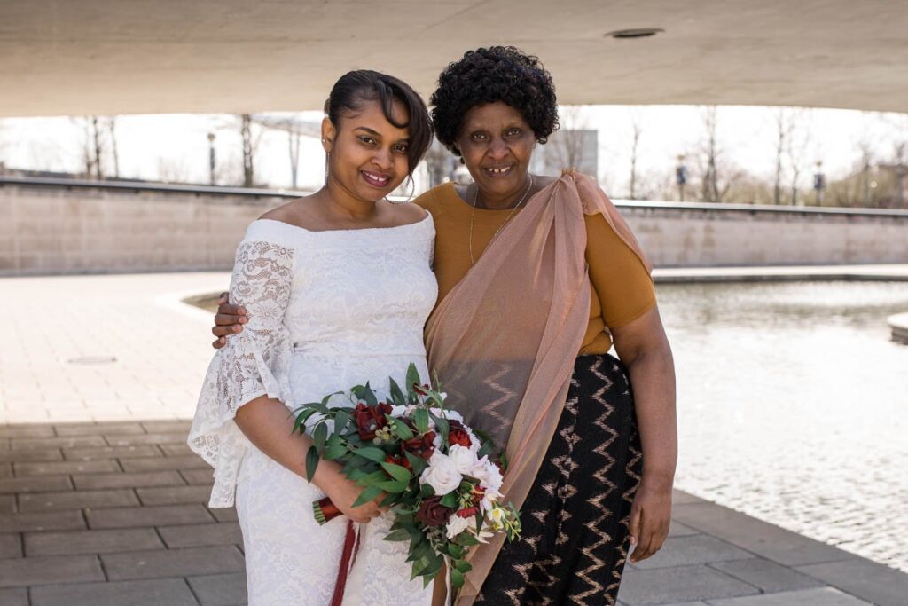 Bride smiles with her mother for a portrait.