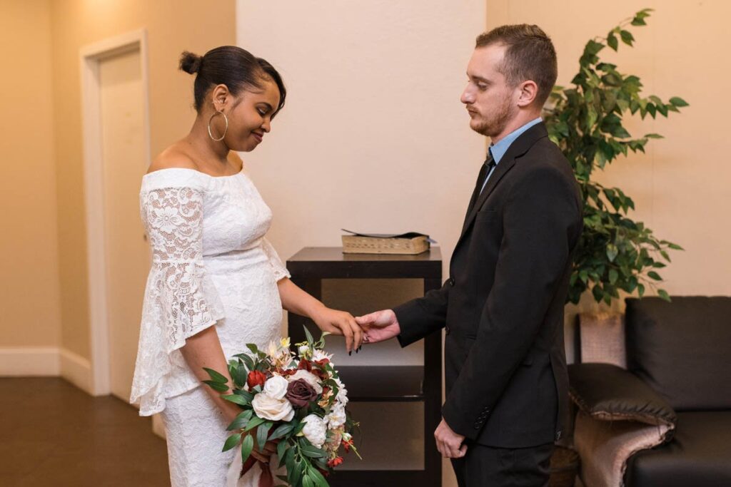 Bride looks down at groom holding her hand during Indianapolis elopement ceremony.