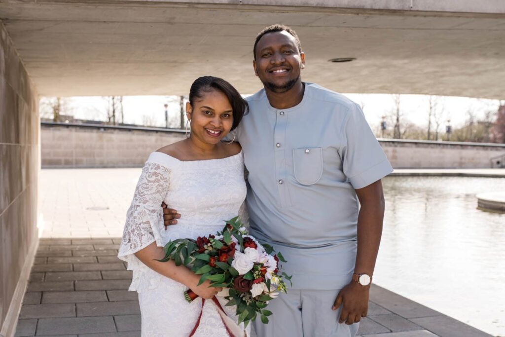 Bride smiles in a portrait with her brother on her wedding day.