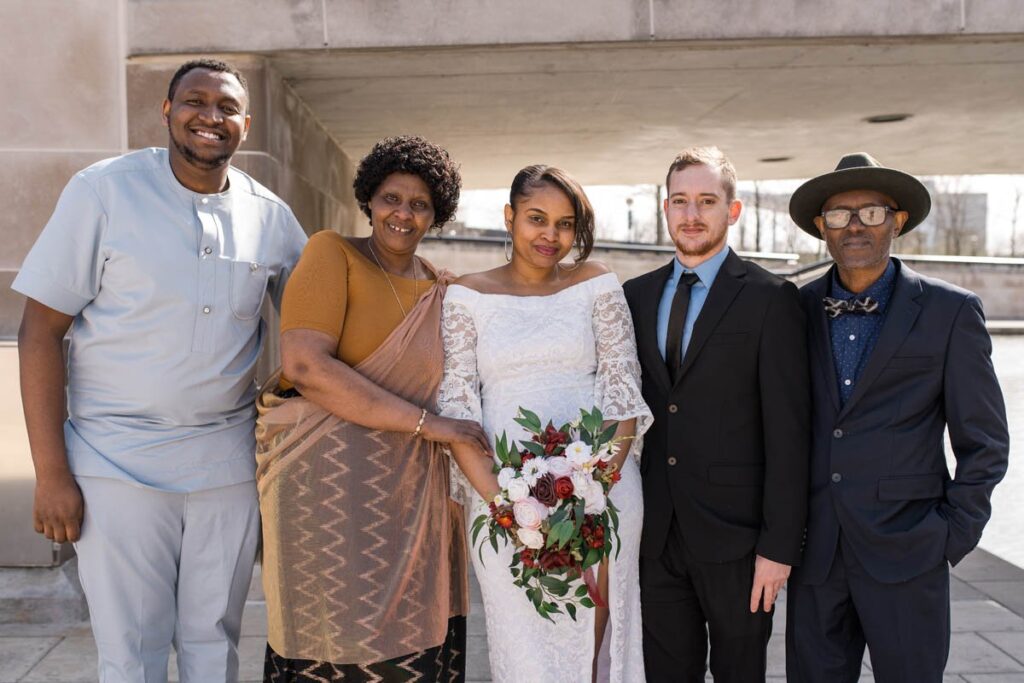 Bride and groom smile with bride's family at their Indianapolis elopement.
