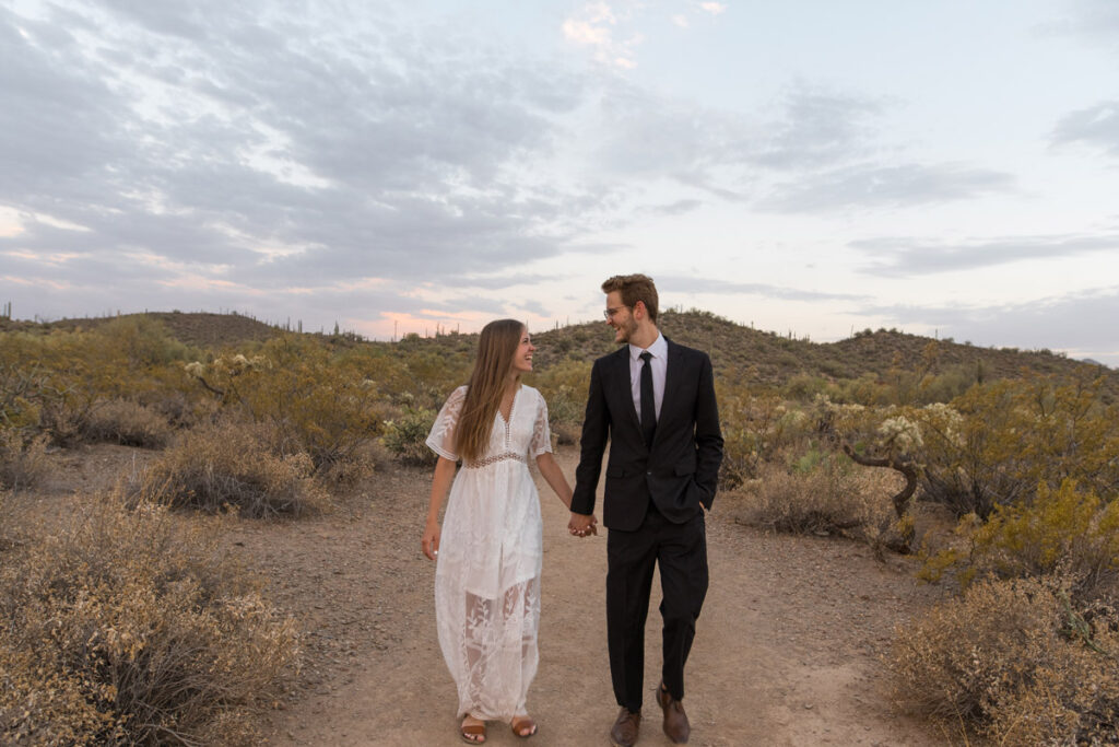 Leave No Trace aware photographer captures bride and groom walking together on a trail in the Arizona desert.