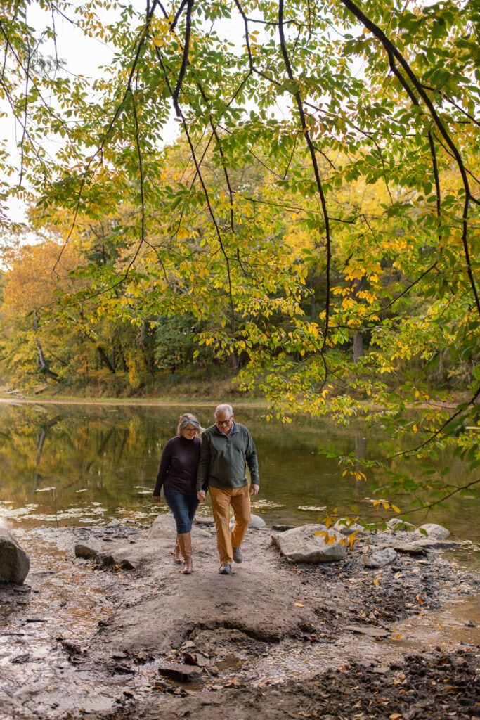 Older couple holding hands and walking together at Shades State Park in Indiana.