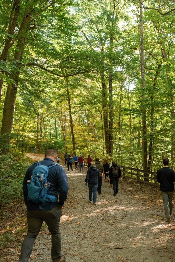 Group hikes together on a large gravel hiking trail at Shades State Park in Indiana.