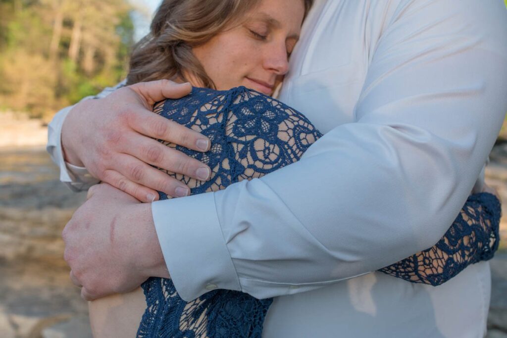 Close up of a woman embracing a man with his arms around her.
