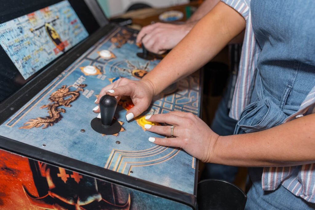 Focus on woman's engagement ring while playing arcade games.