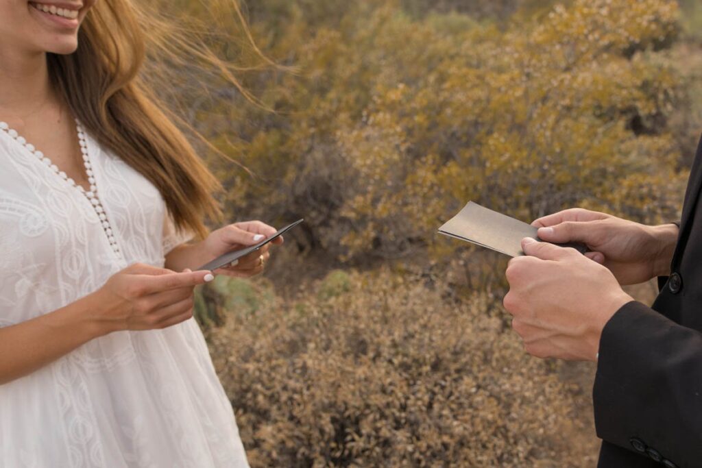 Bride and groom's hands hold letters they've written to one another while eloping in Arizona.