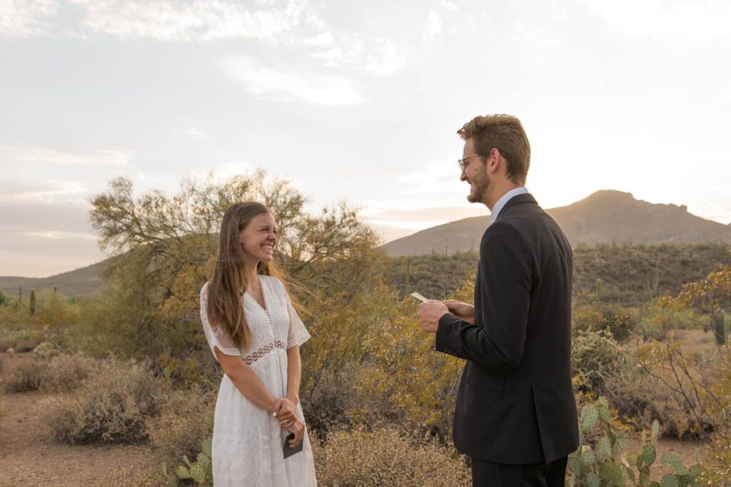 Bride smiles at groom during vows while eloping in Arizona.